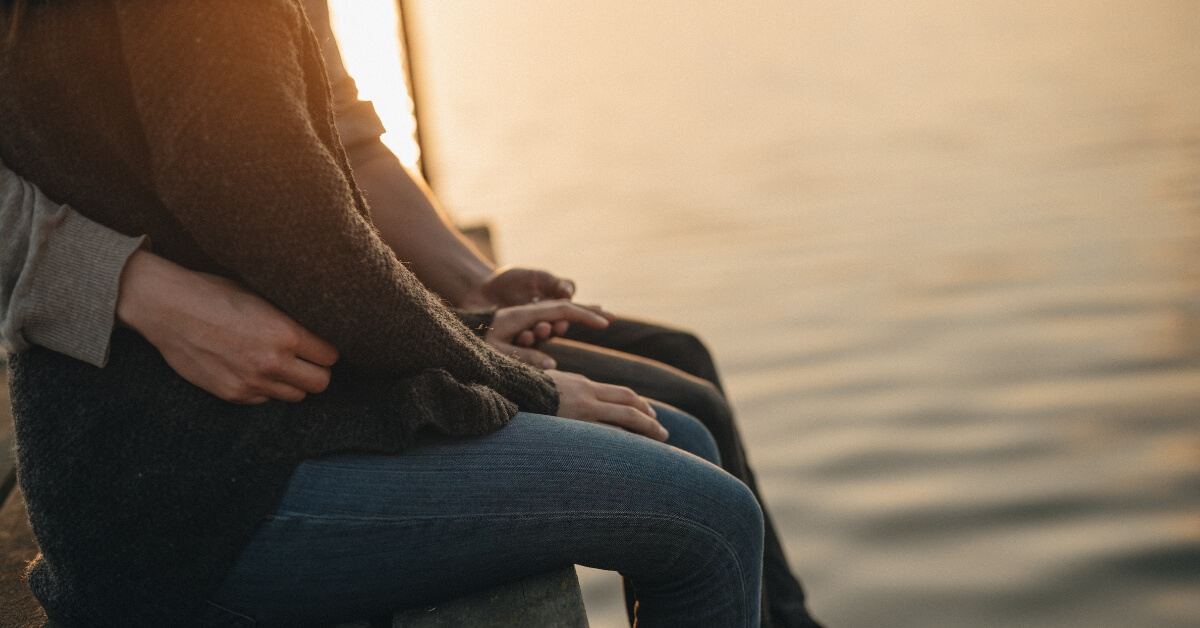 man and woman sitting on a dock