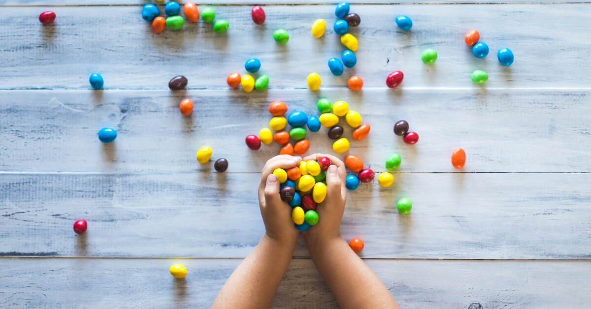 kid holding coloured candy