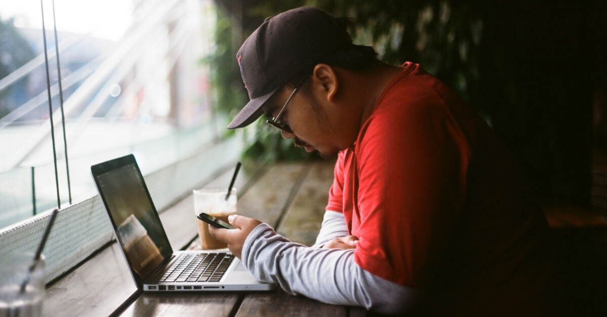 man at a table looking down at his phone