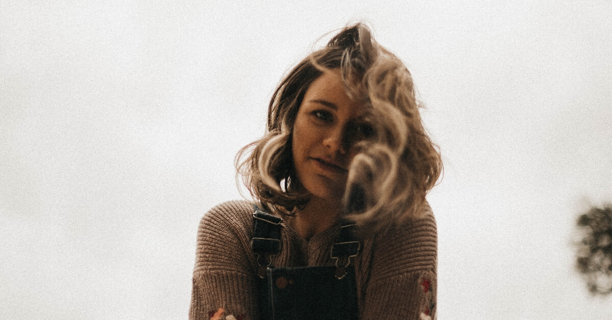 a shy looking young woman with crossed arms