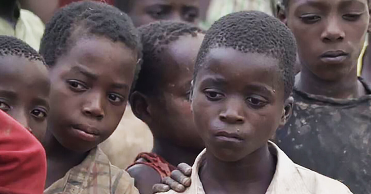 Children in an isolated community in Mozambique wait as World Vision aid packages are distributed to their village.