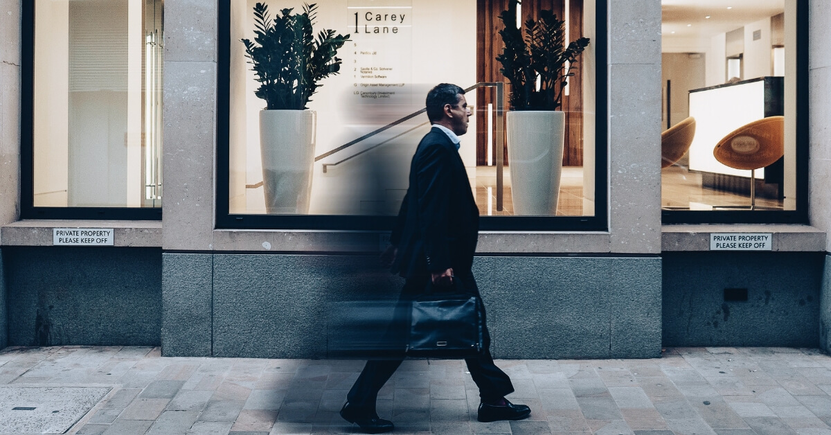 man walking past a store on a street