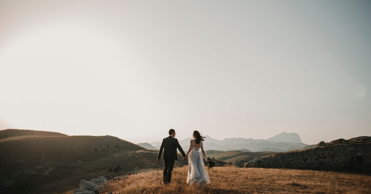 married couple walking on hills in the distance