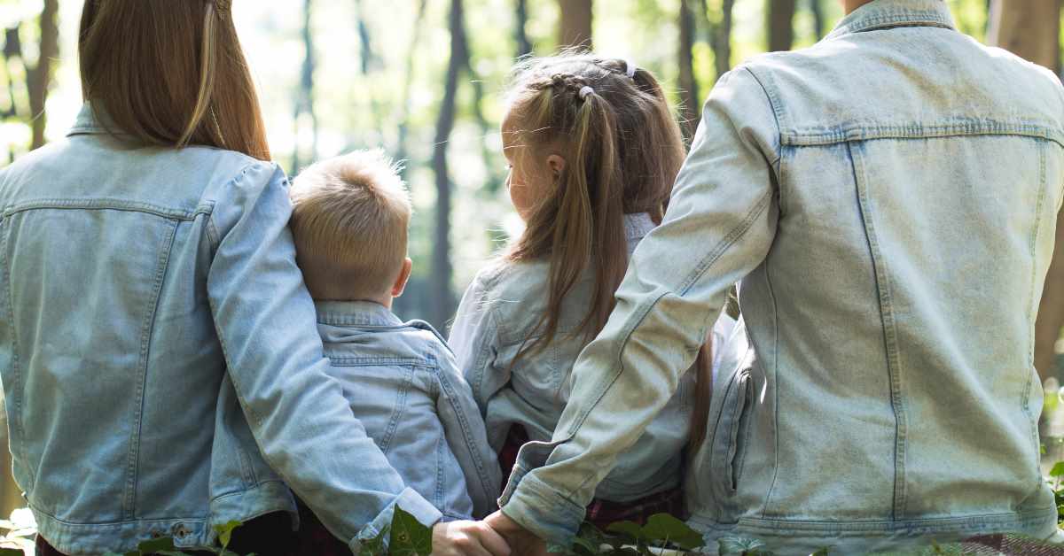 Mother and Father holding hands with two children in between