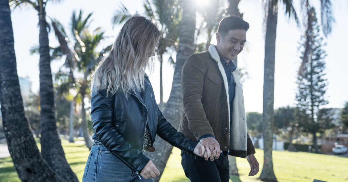 man and woman holding hands in the park