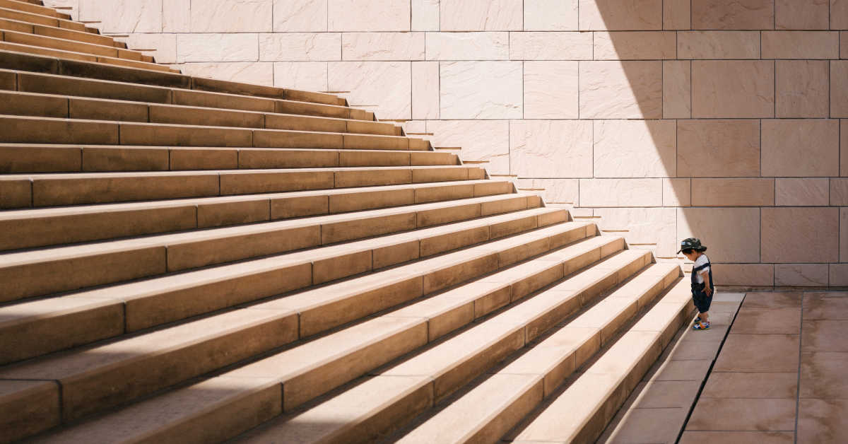 Boy standing at foot of staircase