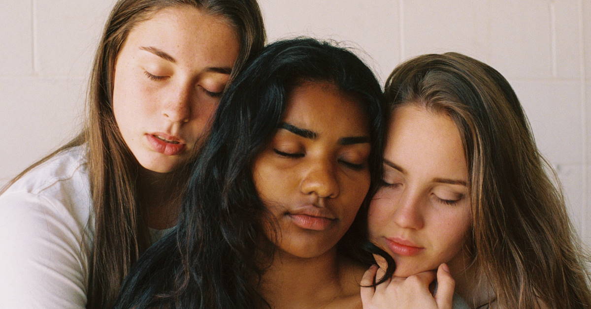 Three girls with eyes closed looking sad