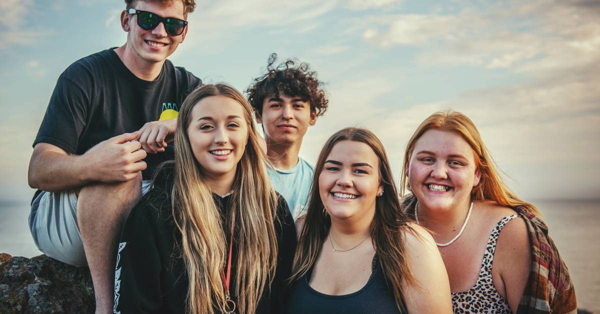 boy and girl teens smiling facing camera