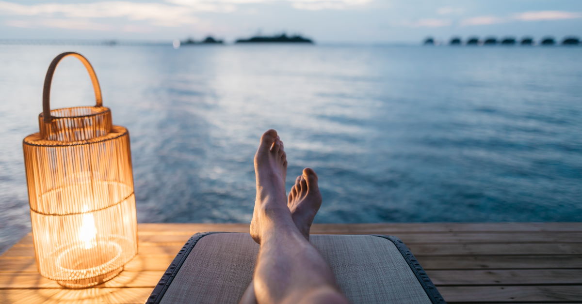 legs stretched out lying down in front of a water view