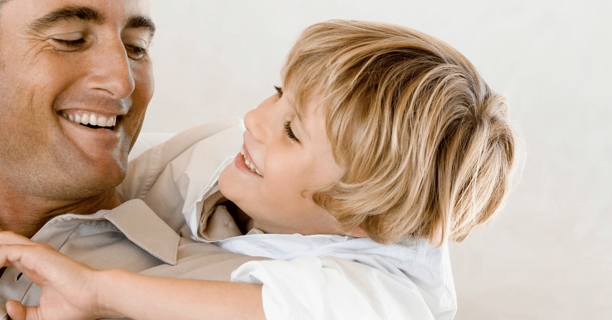 closeup of boy hugging father both smiling and happy