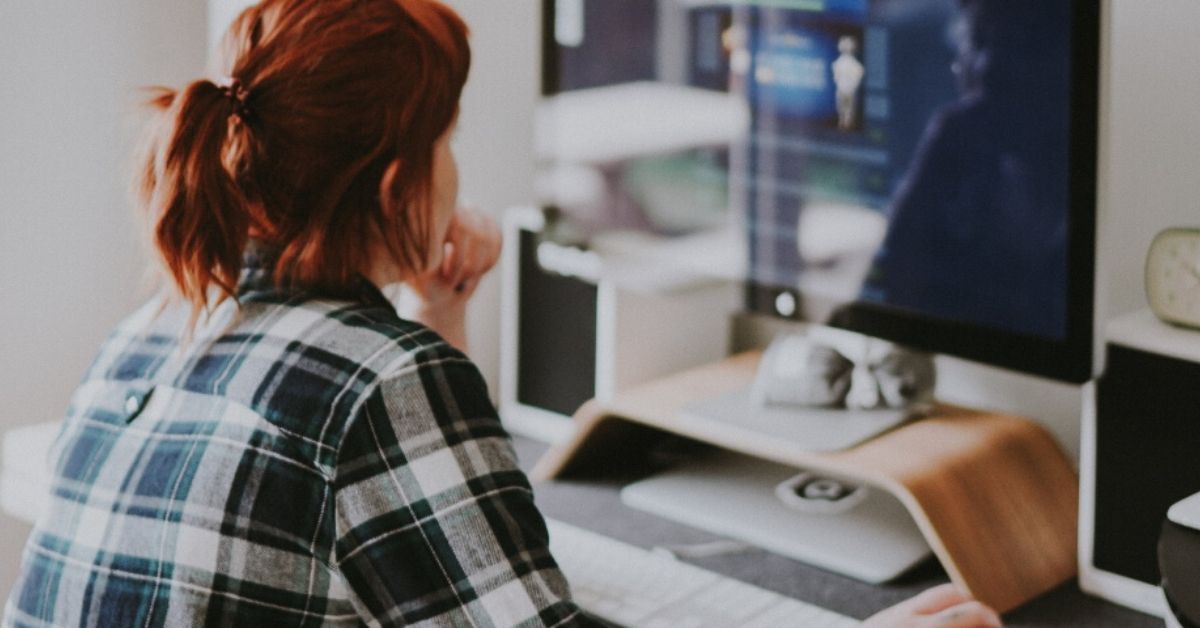 woman sitting at her desk looking at computer