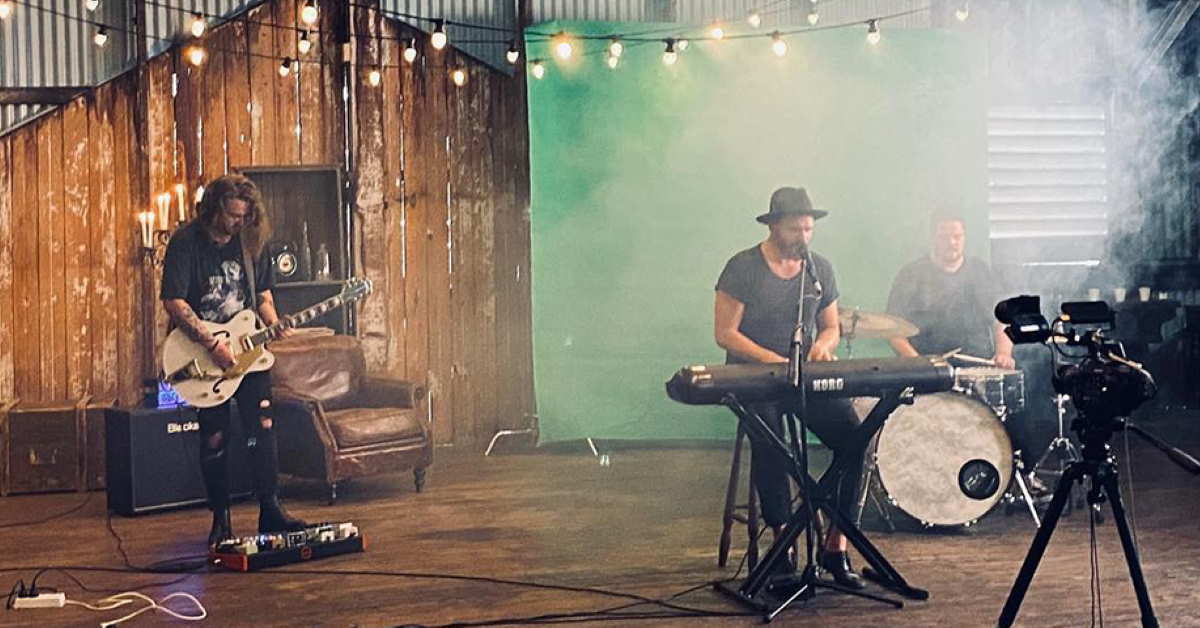 Musicians in barn like setting with Greg Attwells on main vocals and keyboard