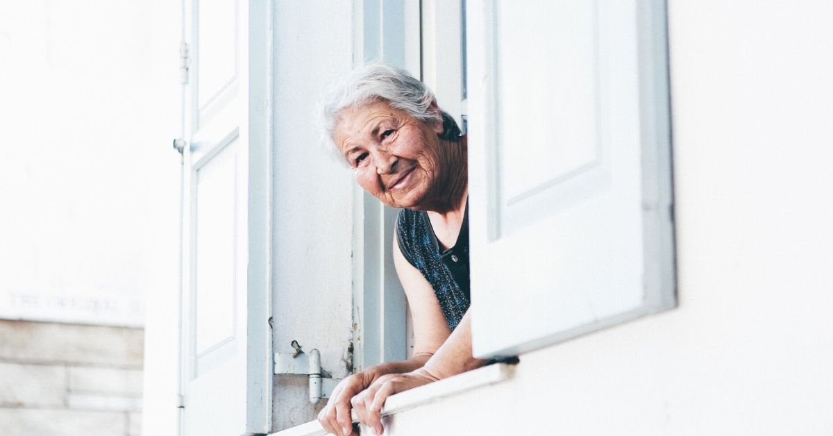 photo of a senior woman with her head looking out a window