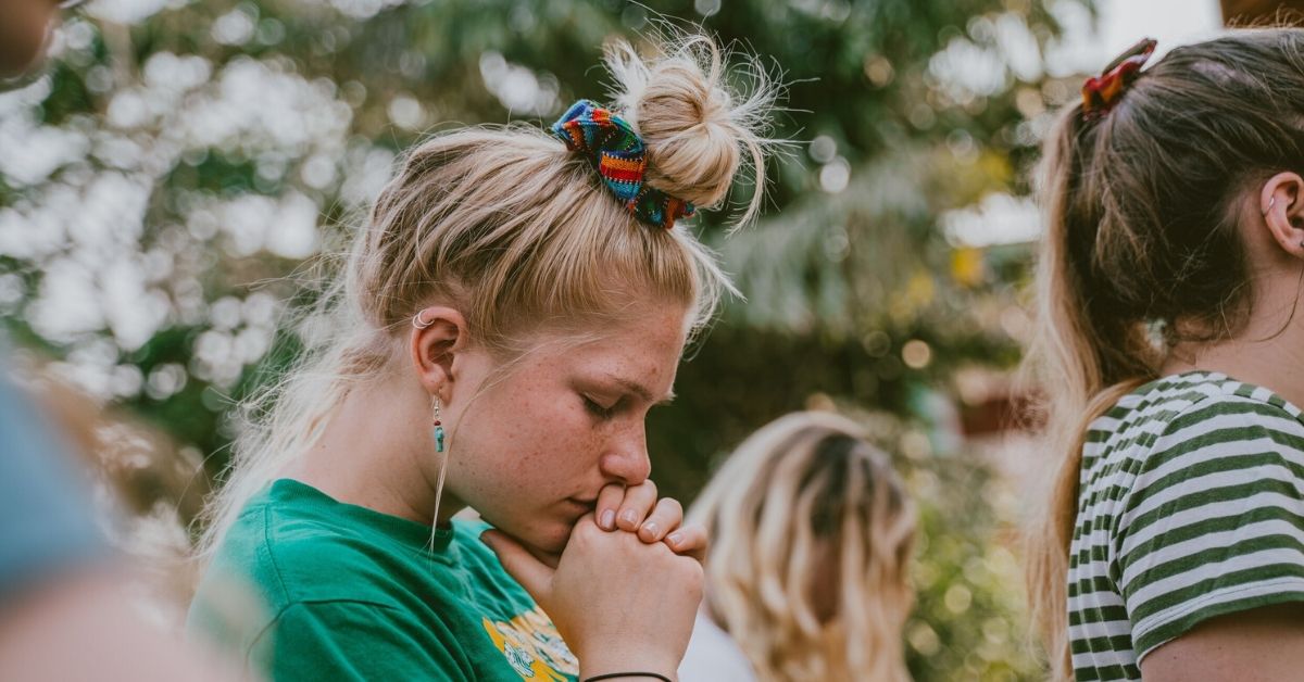 woman with head bowed in prayer