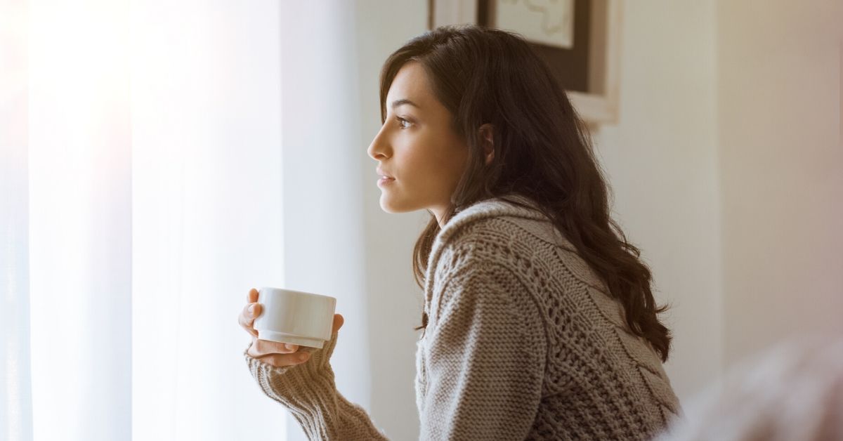 woman holding a mug thinking