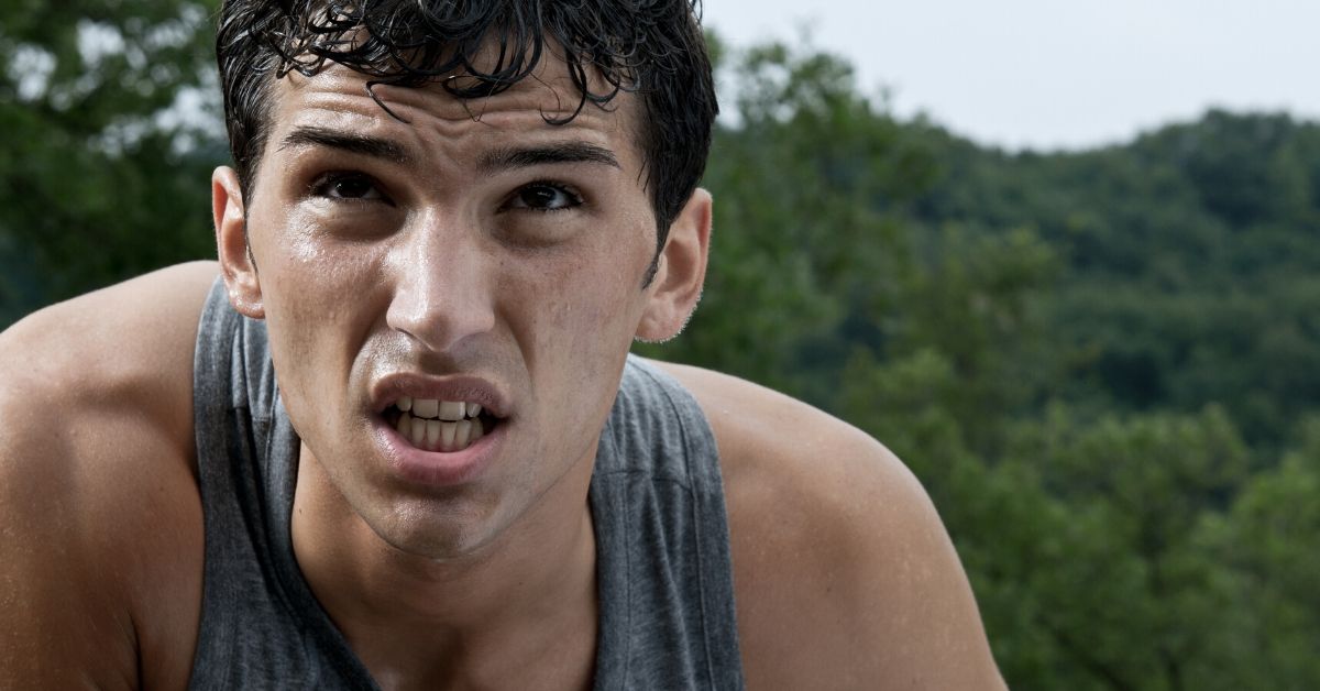 photo of an athlete bent over looking up with a determined expression