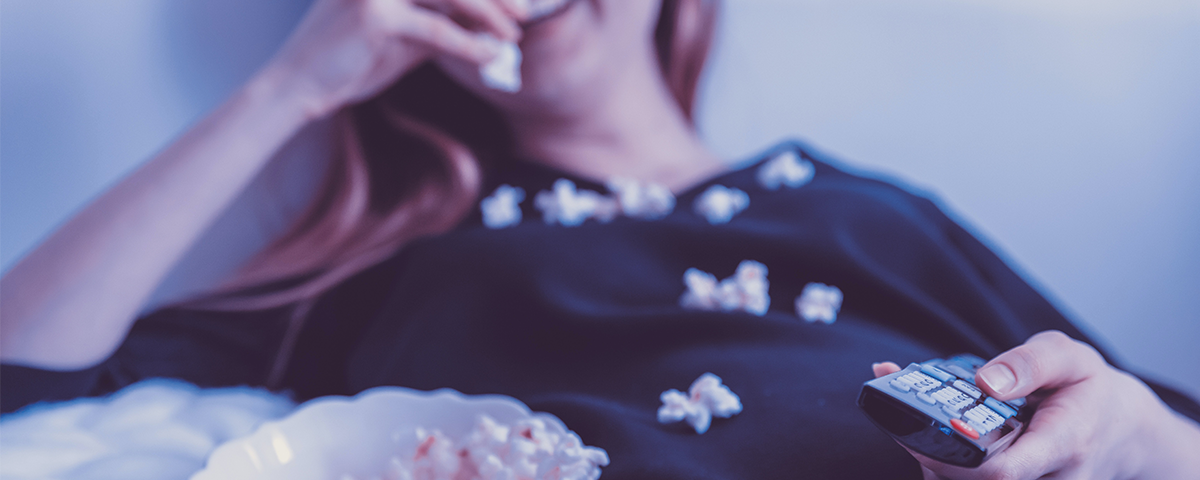 image of a woman lying back eating popcorn