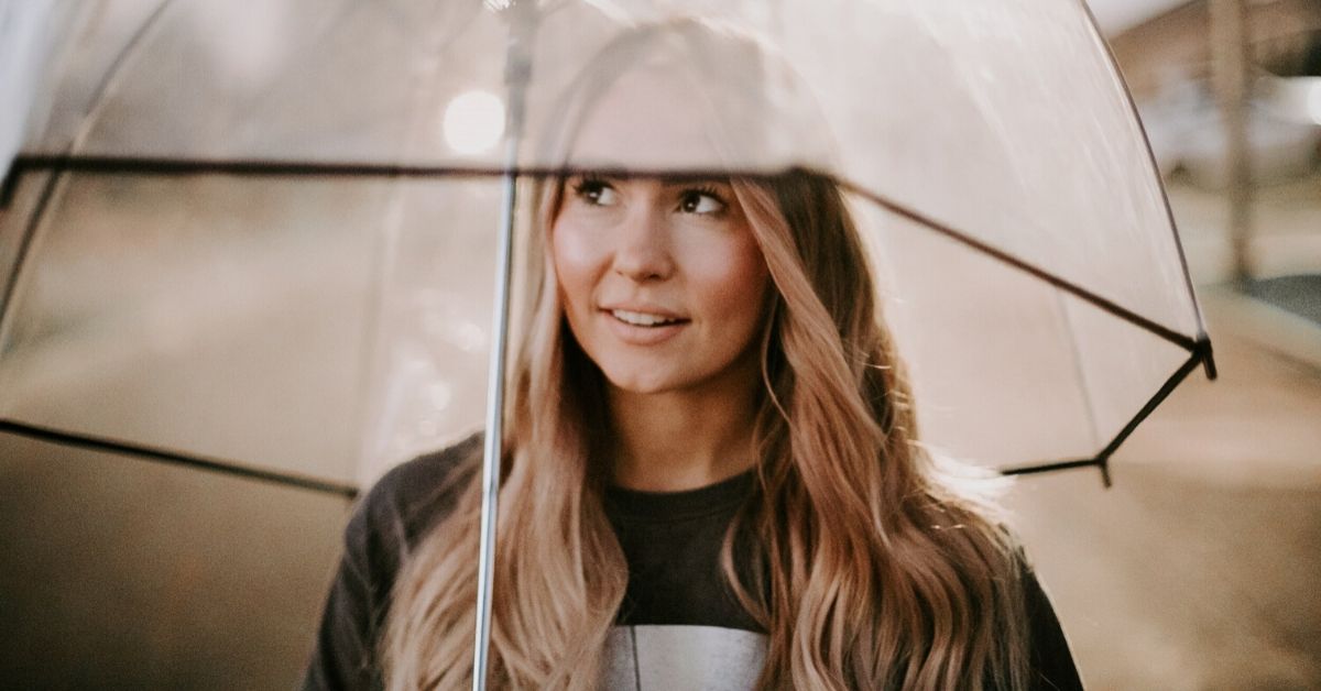 girl standing under an umbrella