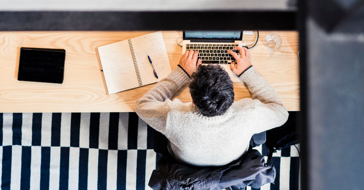 aerial photo of a man on his computer at a desk