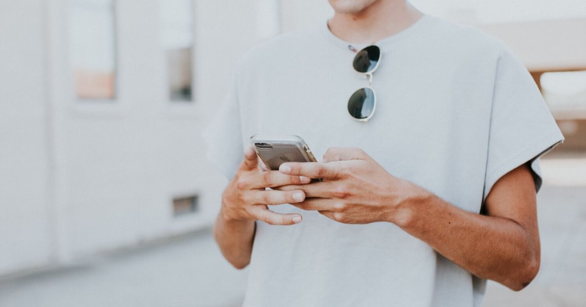 young man looking down at his phone