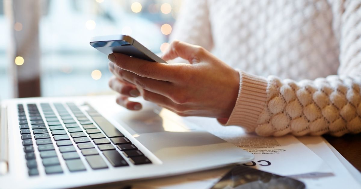 person texting in front of computer