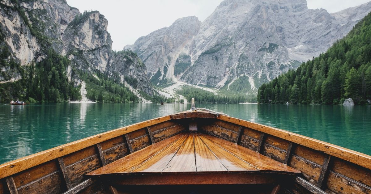 boat on still water with snowy moutains in background