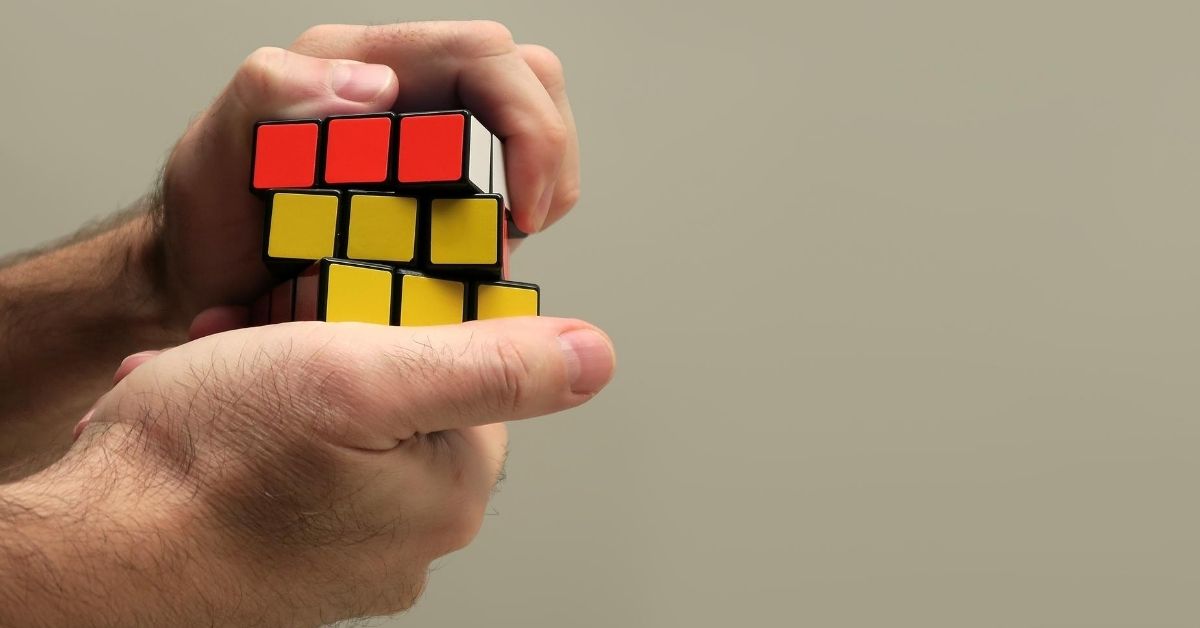 hands working on a rubik cube