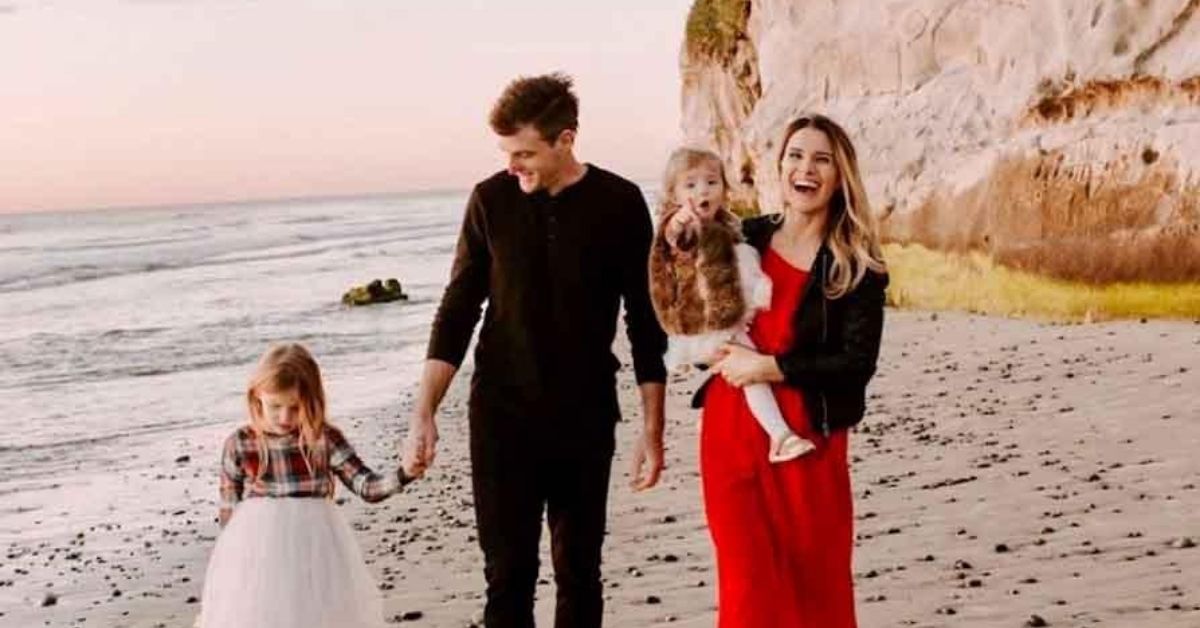 rebecca st james and family on a beach at dusk