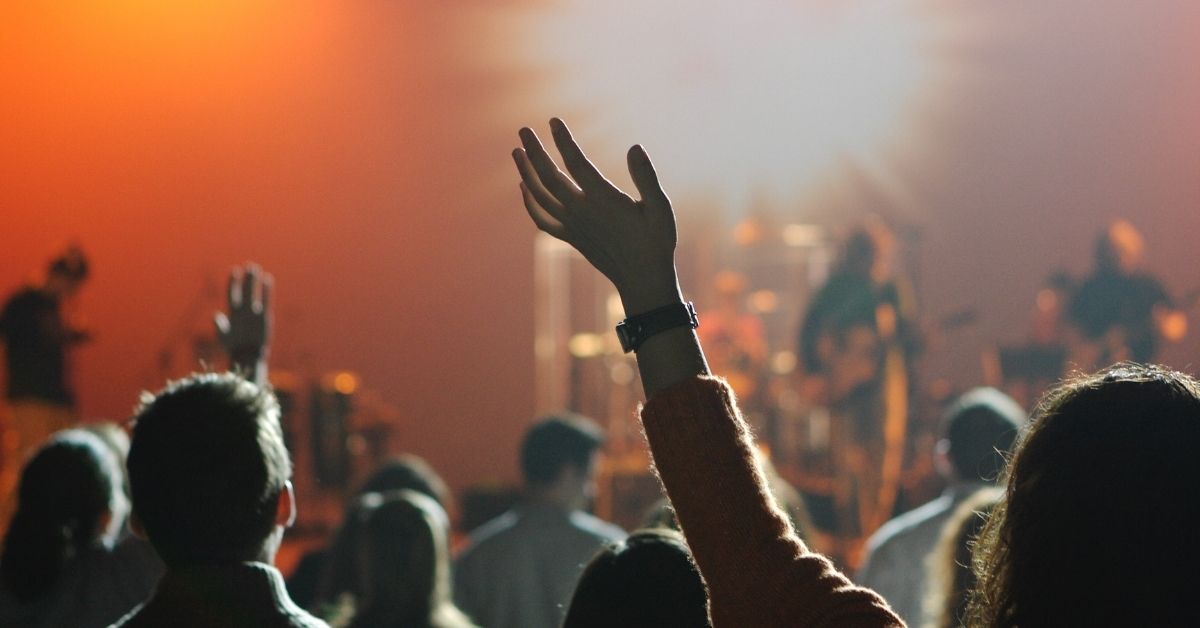 a person with raised hands in a church service