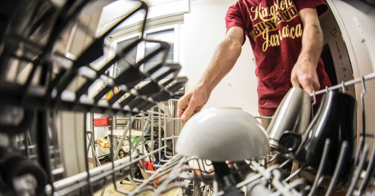 boy loading a dishwasher