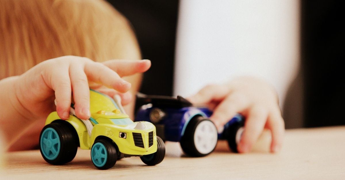 kid uses his imagination while playing with toy trucks