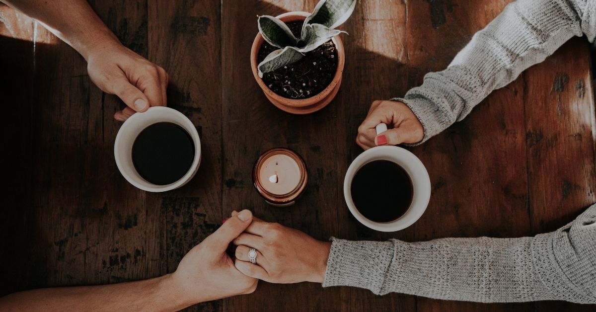 a couple holding hands across the table