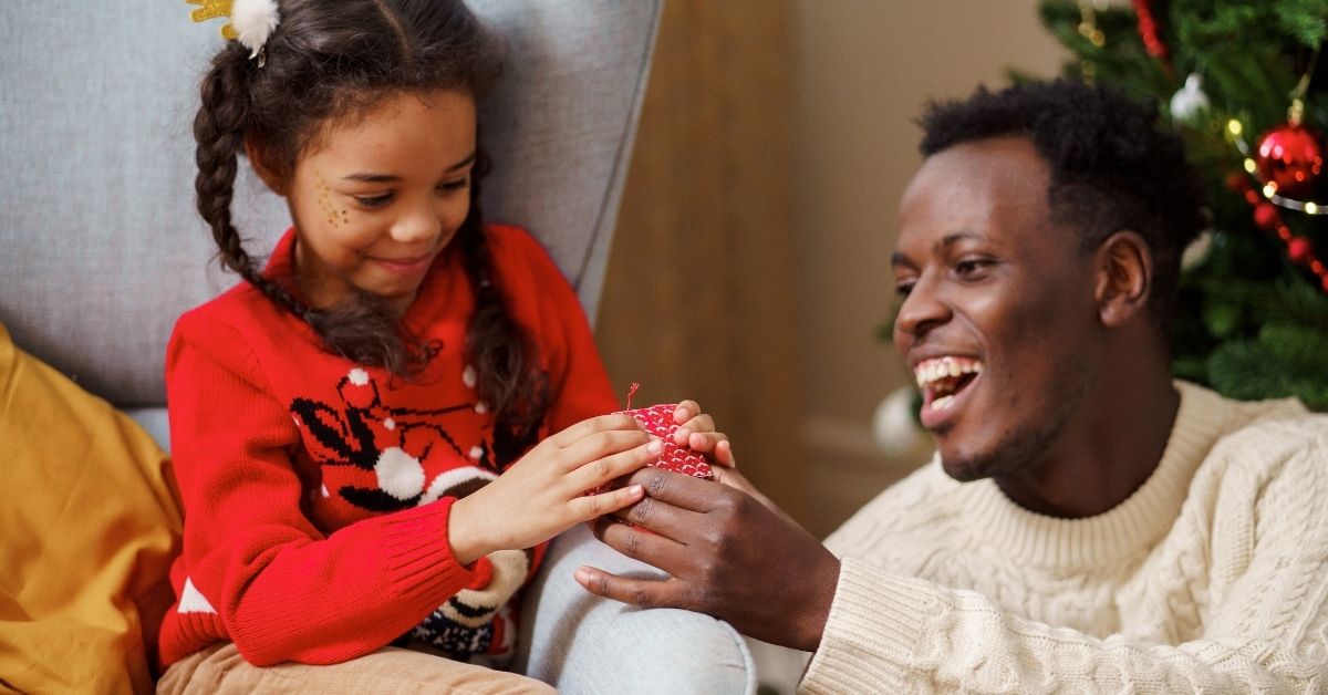 a girl gives a christmas gift to her father