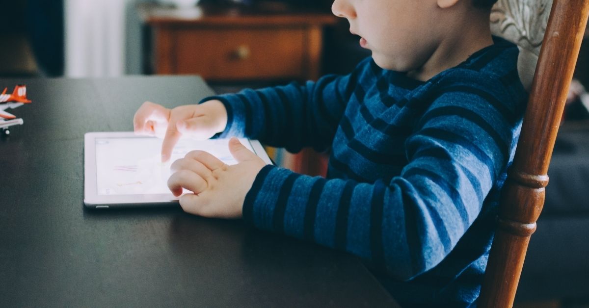 young boy playing on an ipad