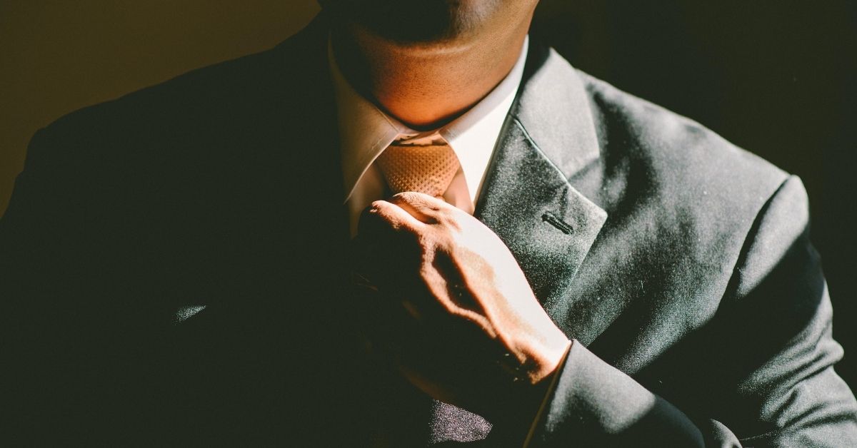 man adjusting his tie