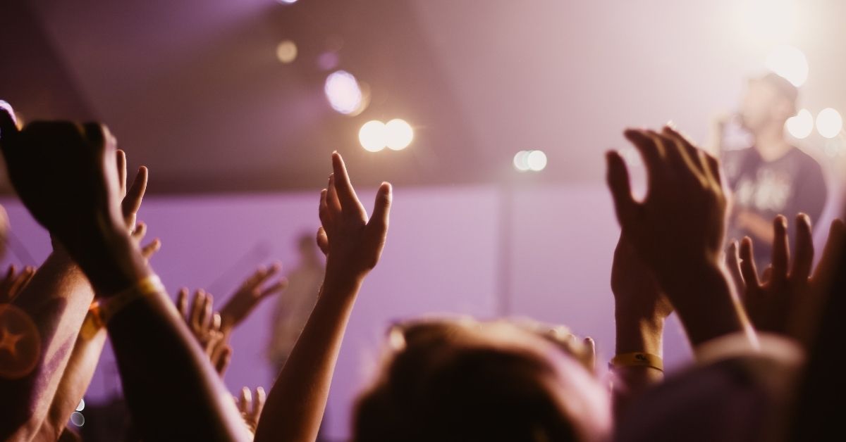 a crowd claps for a performer