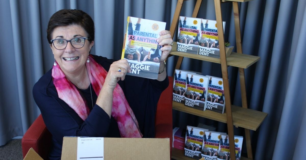 maggie dent holding a copy of her book parental as anything