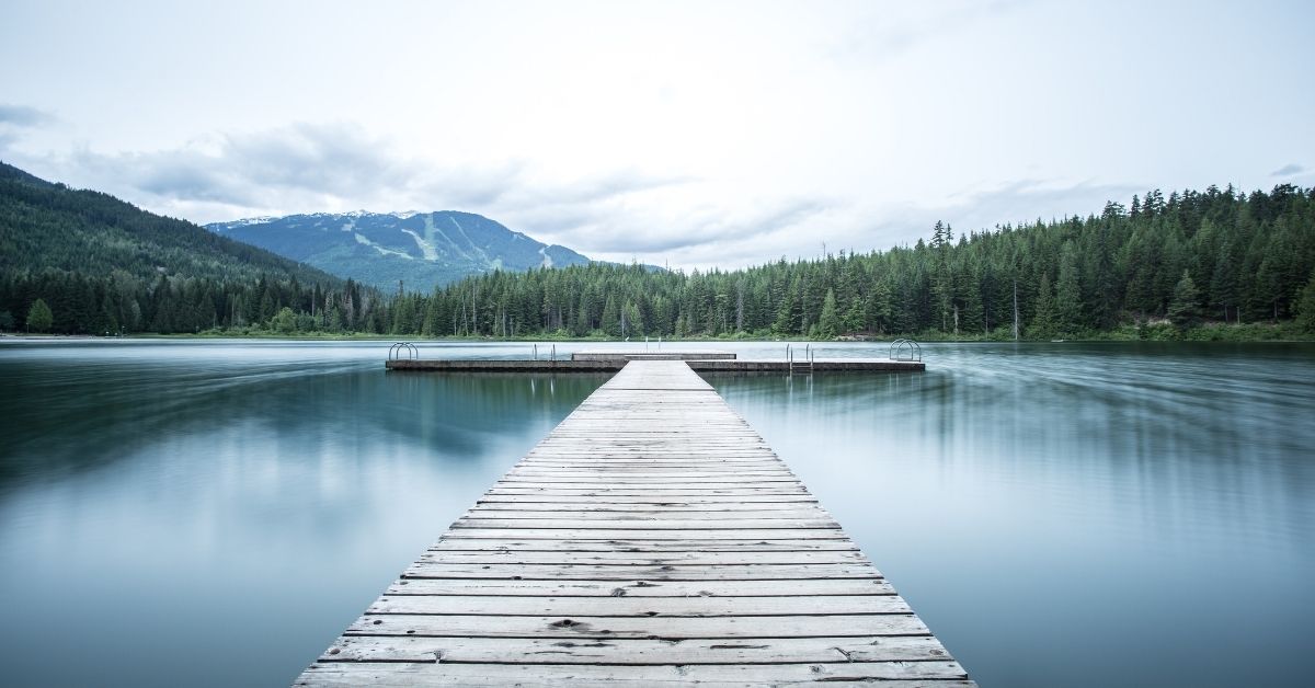 a jetty leading out onto a calm lake