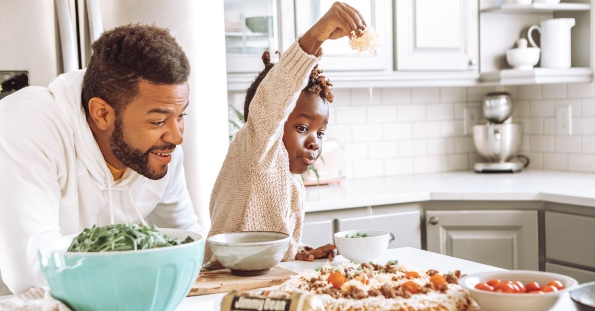 a father and child making home made pizza together