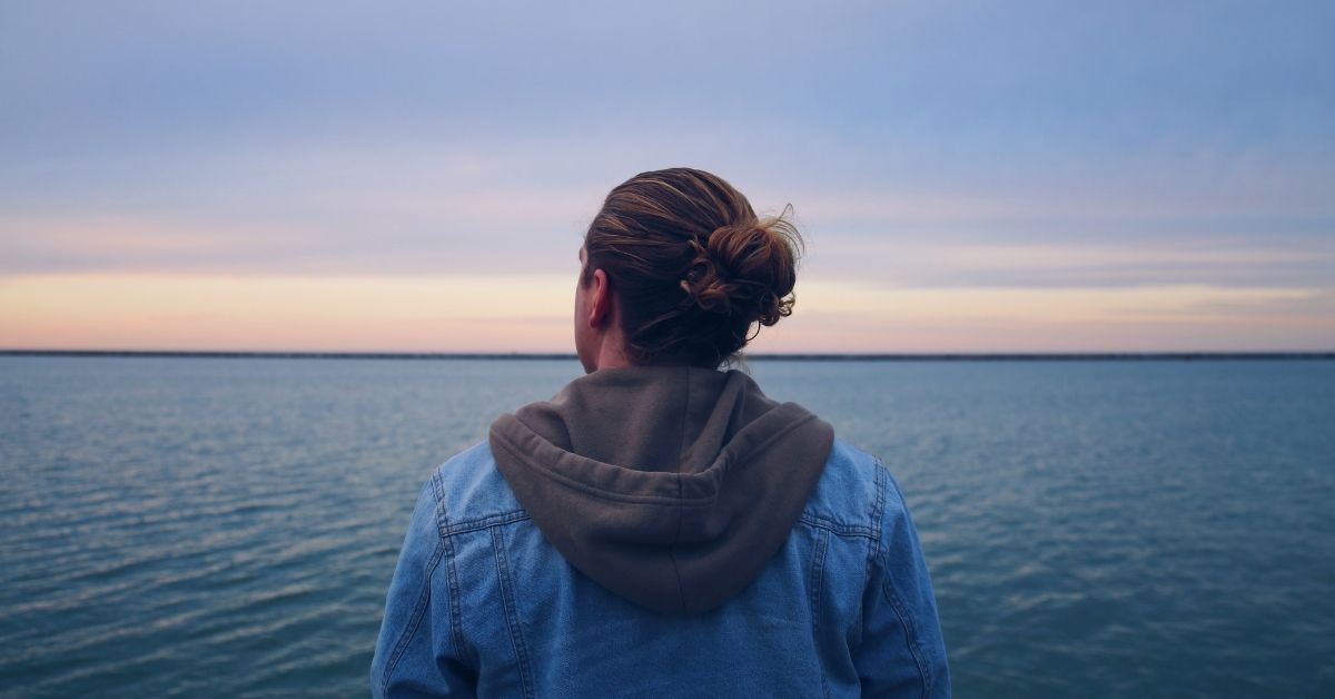 a man gazes out pensively over the ocean