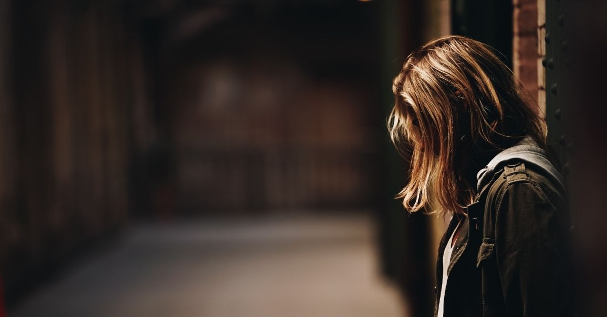 woman with head bowed and with her hair hiding her face