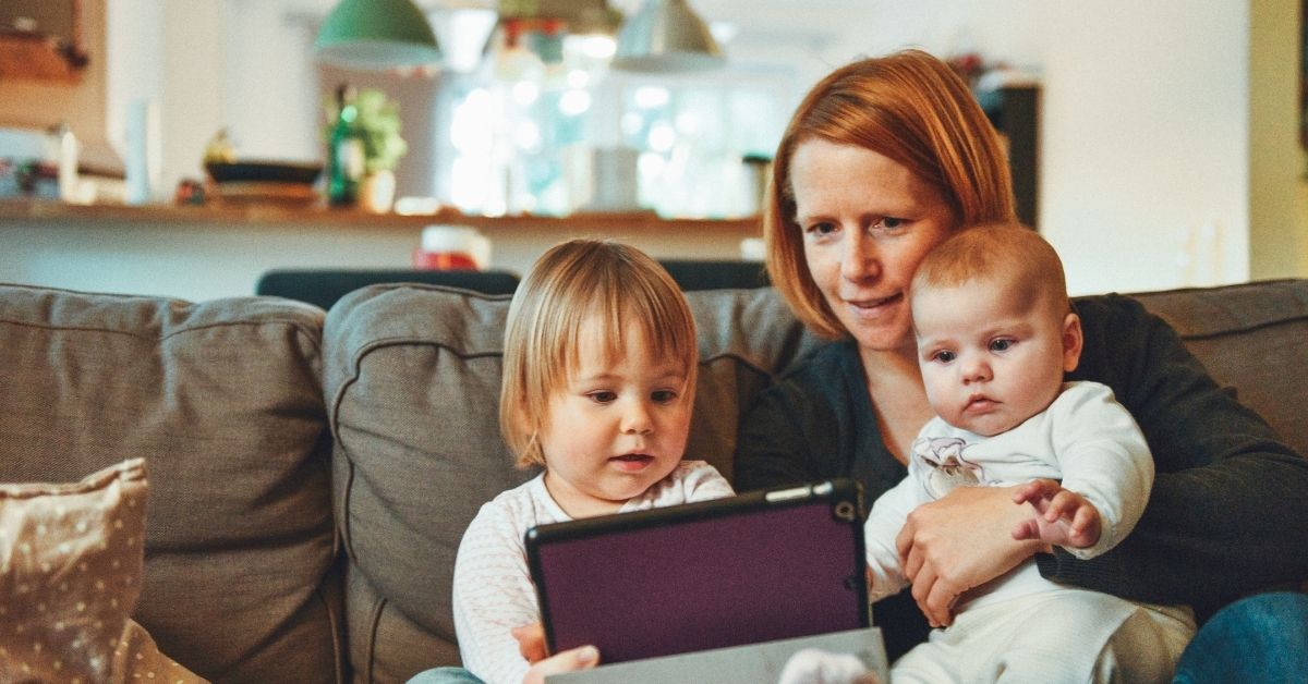 a mum and her child and baby watching something together on a tablet