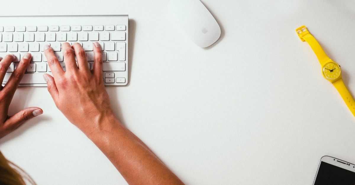 a person's hands typing on a keyboard