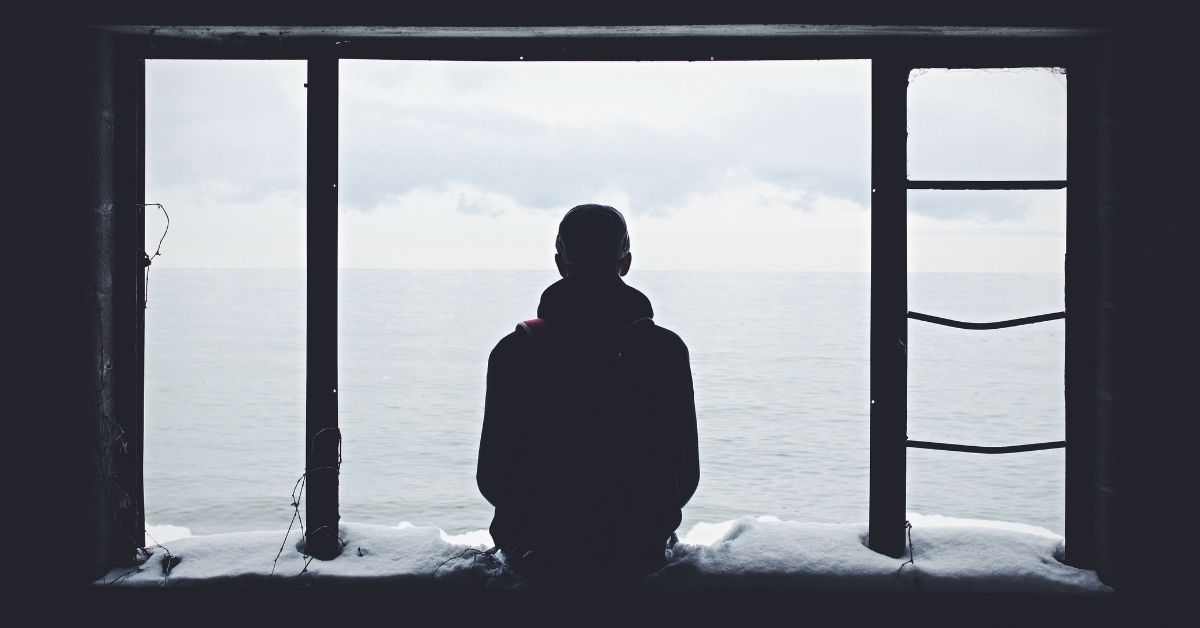 man sitting gazing out over a body of water