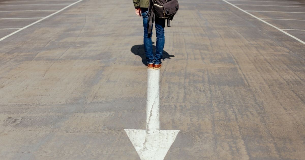 A man walking away from an arrow - against the flow