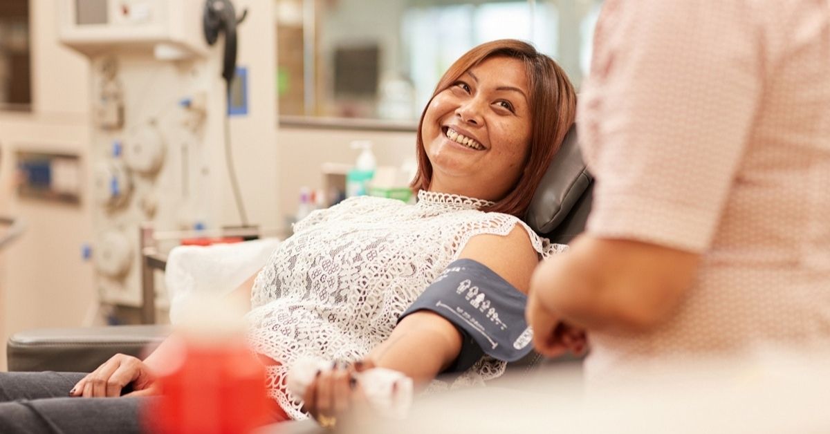 a woman lays in a reclining chair as she gives blood at a lifeblood centre